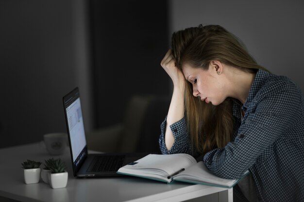 Free photo side view of beautiful woman working at desk