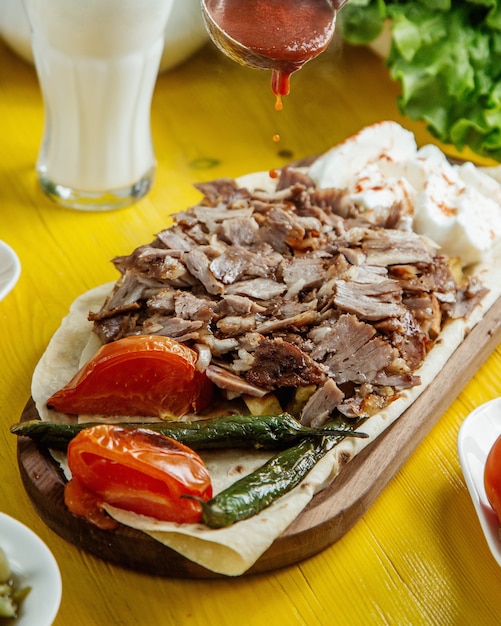 Side view of beef doner kebab on the plate with grilled vegetables