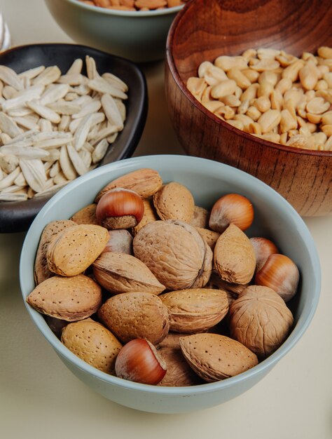 Side view of beer snacks mix of nuts sunflower seeds and salted peanuts on white