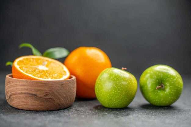 어두운 테이블에 신선한 오렌지와 녹색 사과와 혜택 과일 샐러드의 측면보기