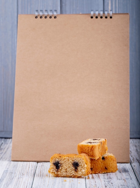 Side view of biscuit cake with chocolate at sketchbook background