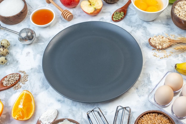 Side view of black plate and ingredients for the healthy food set on ice background