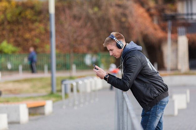 Side view blonde man listening to music outdoors