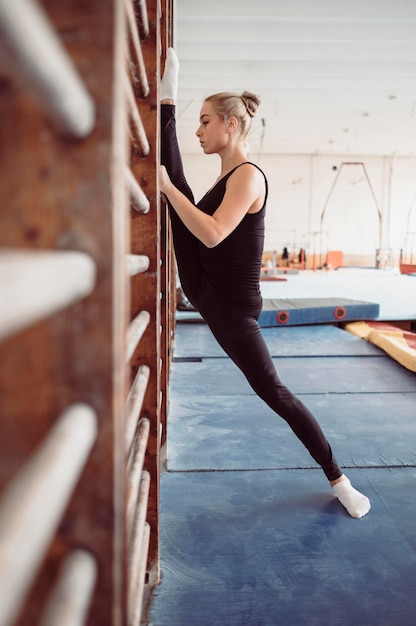 Side view blonde woman exercising for gymnastics olympics