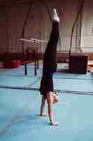 Free photo side view blonde woman training for gymnastics olympics