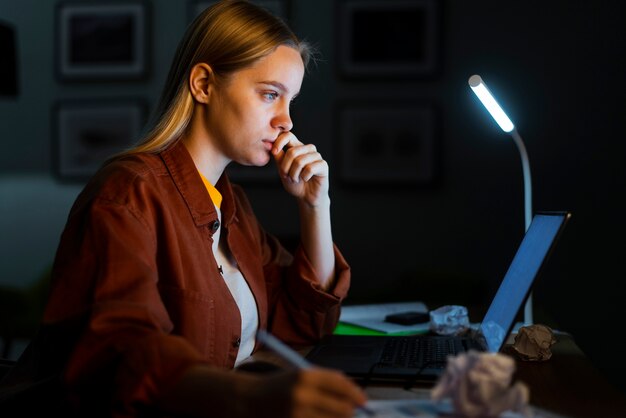 Side view of blonde woman working at laptop