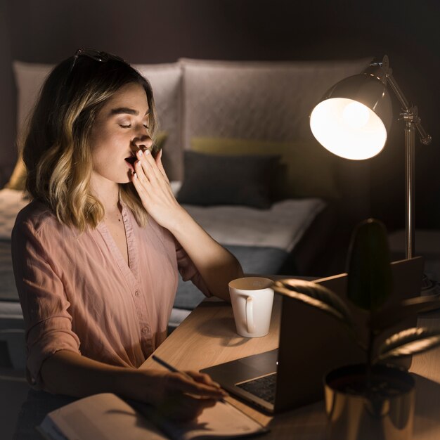Side view of blonde woman working late