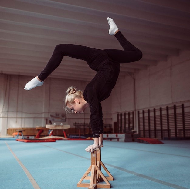 Free photo side view blonde young woman training on wooden pieces