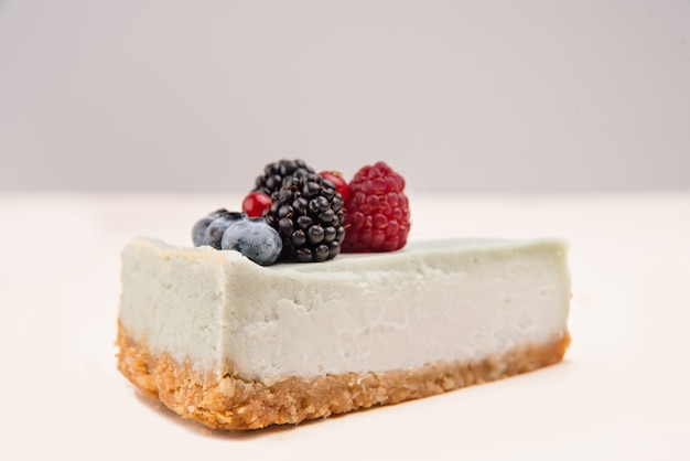 Vista laterale della cheesecake blu con bacche diverse su di esso