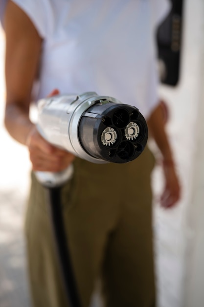 Side view blurry woman holding car charger