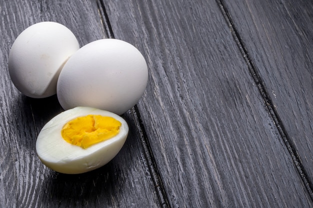 Free photo side view of boiled eggs on wooden rustic