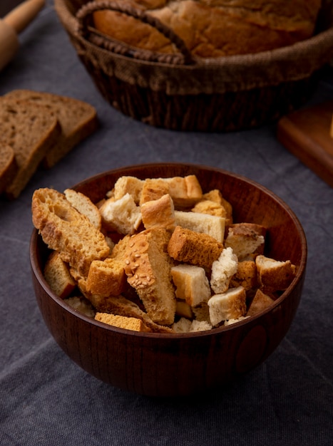 Side view of bowl full of bread pieces on maroon background