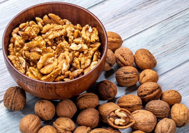 Side view of a bowl with walnuts on rustic