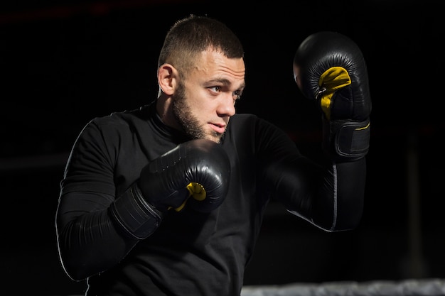 Side view of boxer posing in protective gloves