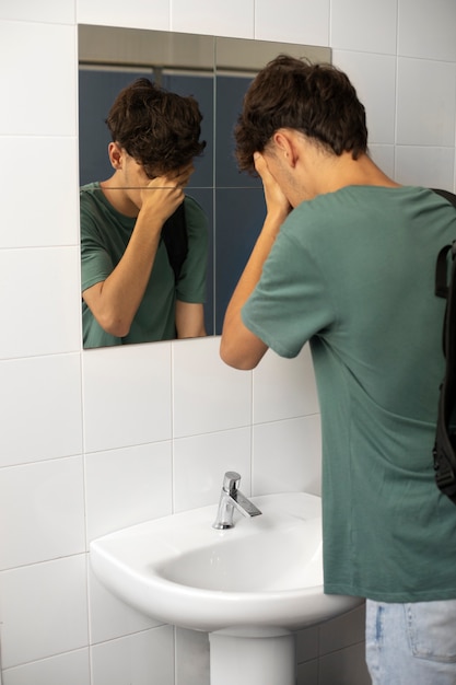 バスルームで泣いている側面図の少年