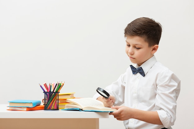 Free photo side view boy at desk reading