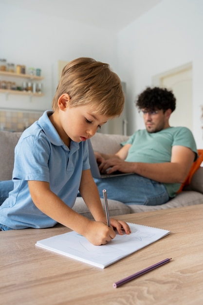 Ragazzo di vista laterale che disegna a casa