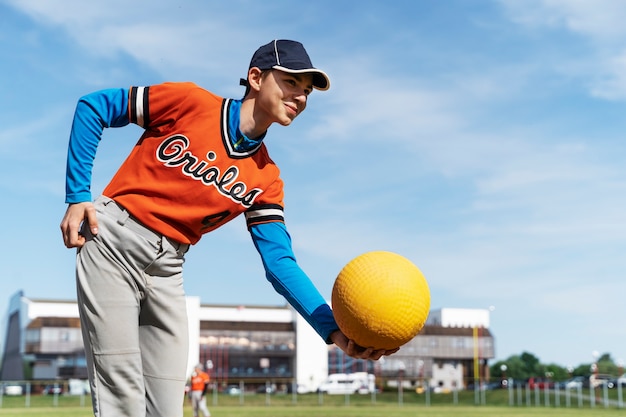 Side view boy holding yellow ball