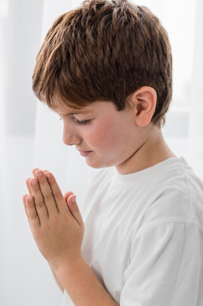 Мальчик молится, вид сбоку