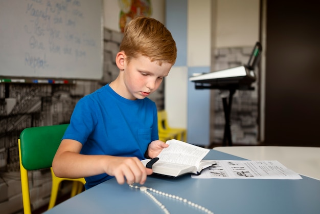 Free photo side view boy reading bible