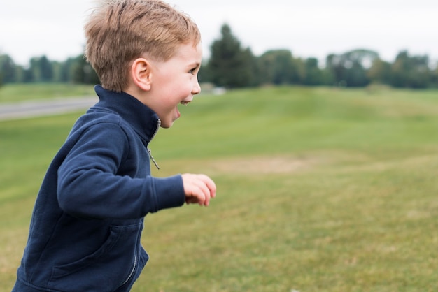 Side view boy running in the park