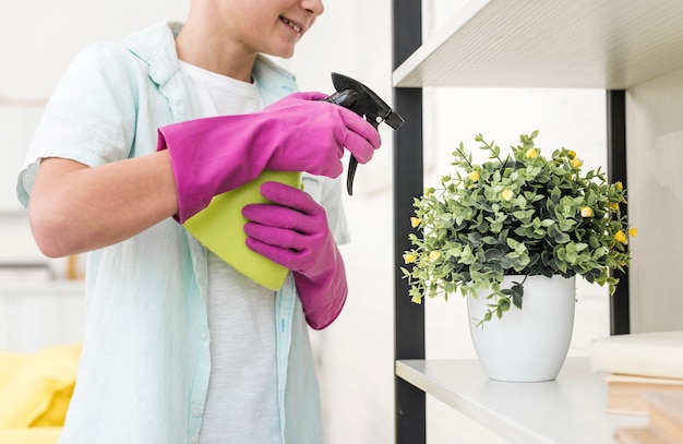 Free photo side view of boy watering plant