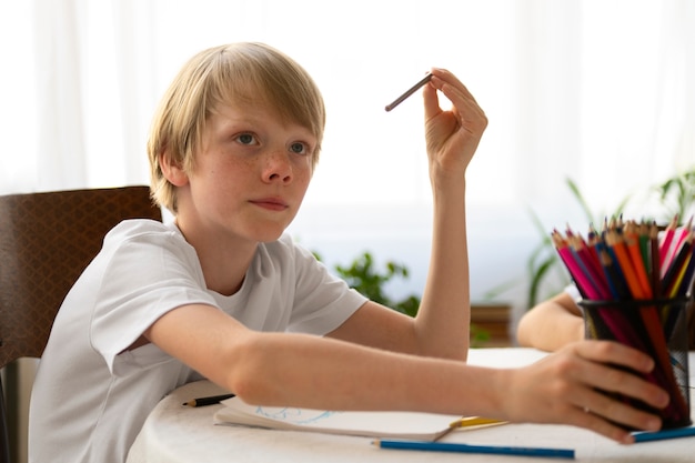 Side view boy with colorful crayons