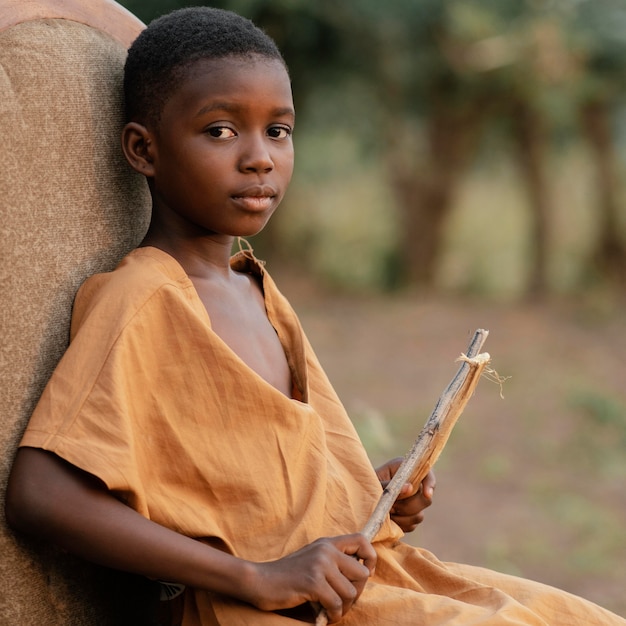 Free photo side view boy with drum sticks