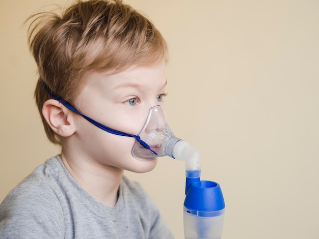 Free photo side view boy with oxygen mask