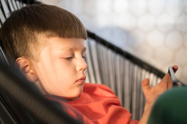 Side view boy with tablet playing