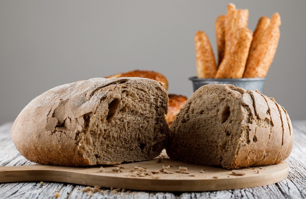 Side view bread divided into half on cutting board with turkish bagel on wooden surface. horizontal