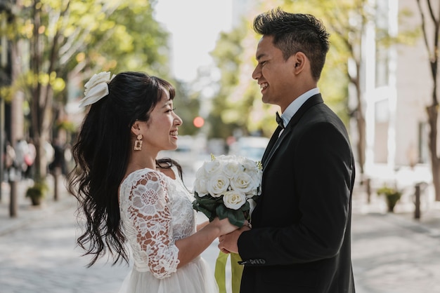 Side view of bride and groom posing in the street