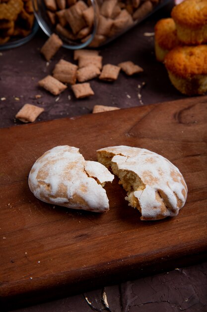 Side view of broken glazed gingerbread on a wooden board