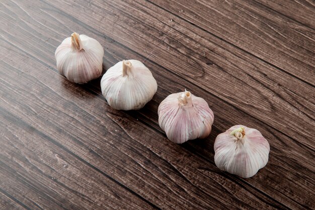 Side view of bulbs of garlic on wooden background with copy space