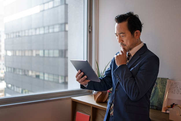 Free photo side view business man holding tablet