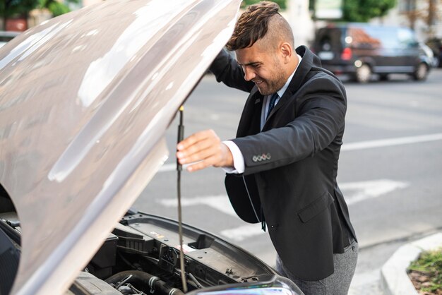 Side view business man looking under the hood