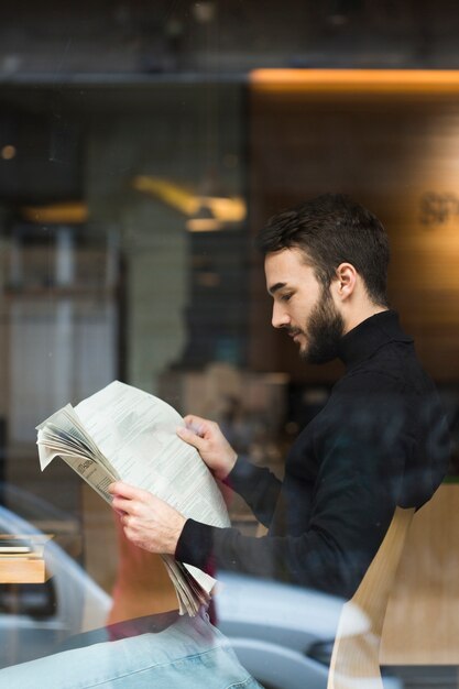 Side view business man reading newspaper