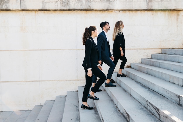 Side view of business people walking upstairs