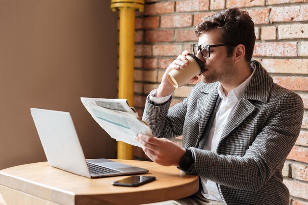 Free photo side view of businessman in eyeglasses sitting by table