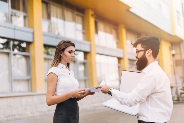 Side view of a businessman showing document to her colleague