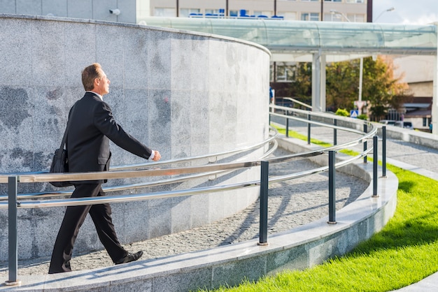 Side view of a businessman walking near railing