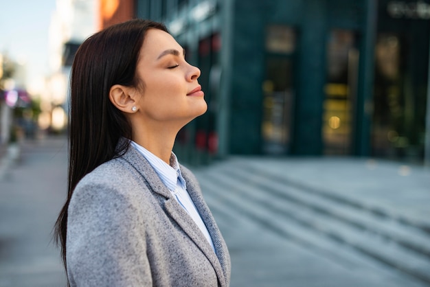 Side view of businesswoman outdoors in the city with copy space