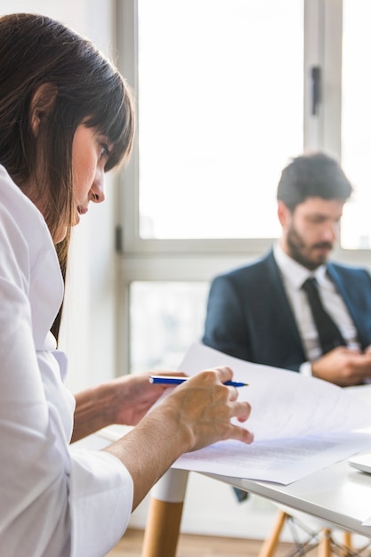 Side view of businesswoman reading document in the office