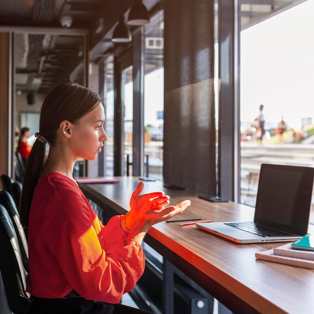 Side view of businesswoman using sign language during video call