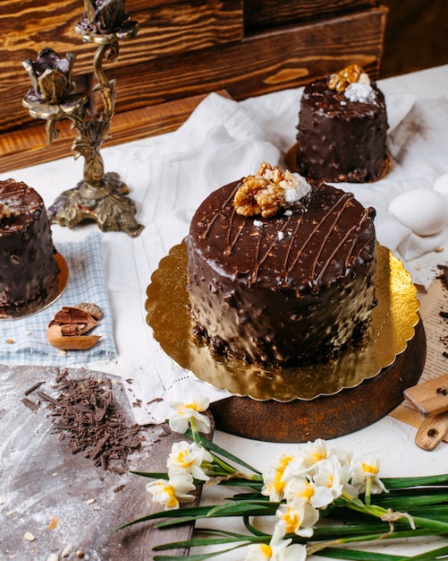 Side view of cake covered with chocolate and walnuts on the table