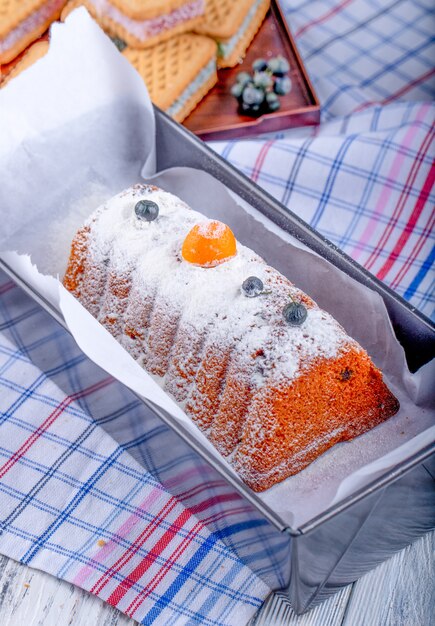 Side view of cake with raisins and powdered sugar on the tablecloth