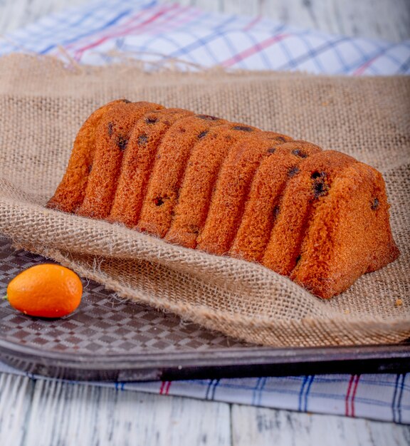 Free photo side view of cake with raisins on rustic background