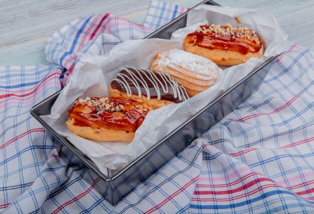 Side view of cakes on plaid cloth and wooden surface