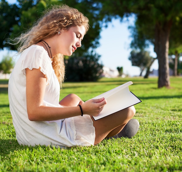 Side view of calm woman reading in the park