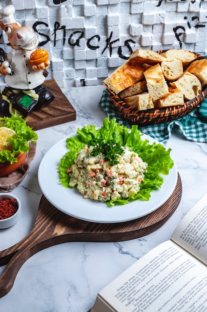 Free photo side view capital salad on lettuce with bread